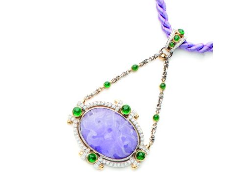 Pendente in oro bianco e giallo 18 ctcon al centro una giada lavanda incisa e sbalzata, con brillanti e smeraldi di contorno.