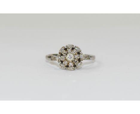 18ct White Gold Set Diamond Cluster Ring flower head setting. The central diamond surrounded by 8 small diamonds. marked 18ct