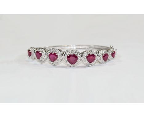 Heart Cut Ruby Bangle, seven graduated rubies, totalling 9.5cts, set in a rhodium vermeil and silver, millgrain type, band of