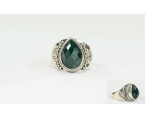 Emerald Solitaire Ring, a pear cut emerald of 8cts, with chequerboard faceting to the surface, bezel set in a hand crafted si