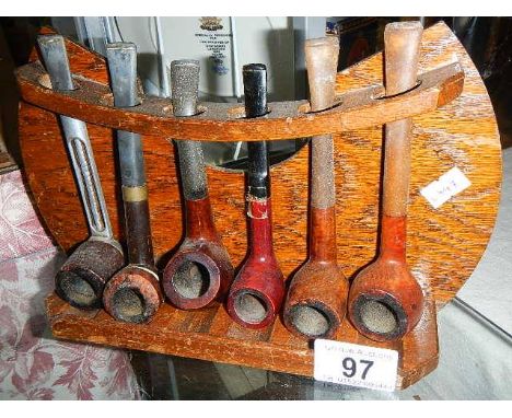 A quantity of old pipes on an oak pipe rack