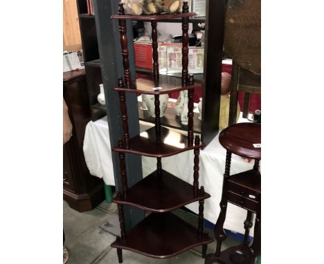 A dark wood stained corner whatnot display shelf unit