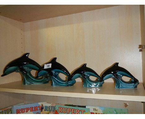 A set of 4 graduated Poole pottery dolphins