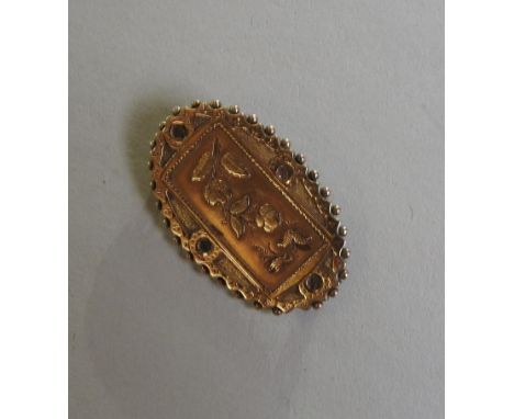 A 19TH CENTURY 9CT GOLD OVAL BROOCH, the central oblong panel with floral decoration, with a beaded edge 3.5 cm wide, 3.4 gra