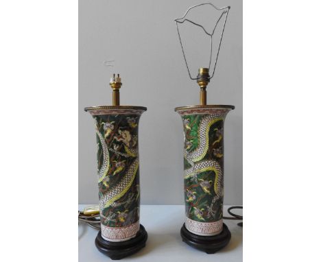 A PAIR OF CHINESE SLEEVE VASES, converted to table lamps, the cylindrical vessels decorated with dragons amongst clouds, set 