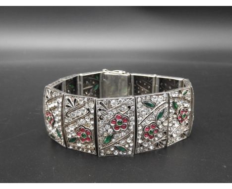 A SILVER AND PASTE BRACELET, circa 1920  12 panels each set with white pink and green paste in a floral pattern with milgrain