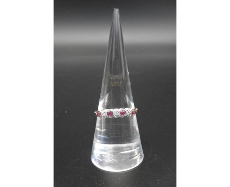 A RUBY AND DIAMOND CHIP RING four small rubies and three diamond chips claw set in a carved head. Marked 9ct&nbsp; Ring size 