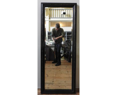 A 19TH CENTURY HALL MIRROR, bevelled mirror panel enclosed in a stained pine frame with notched border pattern, 150 x 57 cm 