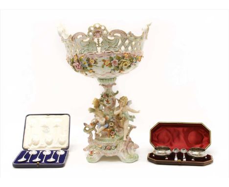 A continental ceramic comport , having applied putti and floral encrusting, together with a set of cased silver spoons and ca