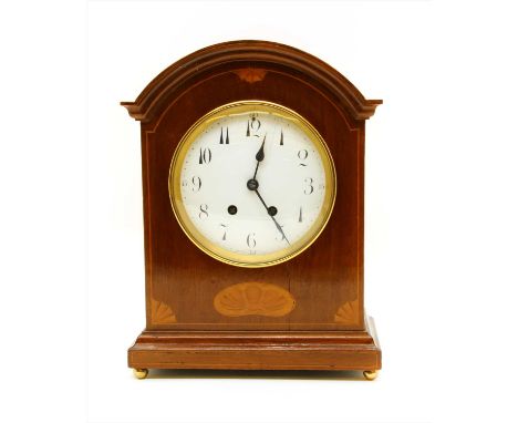 An inlaid mahogany striking mantle clock, the arched top over an inlaid body, the white enamel dial with Arabic numeral hour 
