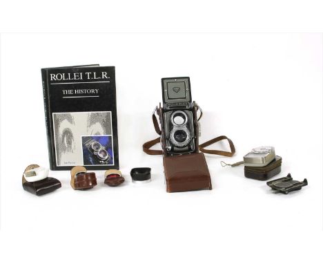 A Rolleiflex twin lens camera, by Franke &amp; Heidecke, in leather case with accessories and a book, 'Rollei T.L.R. - A Hist