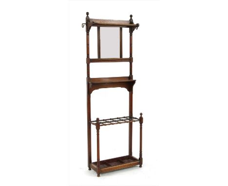 An Arts &amp; Crafts walnut hall stand, with a rail over a mirror, a shelf and an umbrella stand, with a metal drip pain, wit