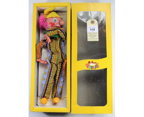 A Pelham Puppet Clown SM1. A Clown in multi striped/patterned one piece, with pink hair and yellow felt cap. Boxed, a good wi