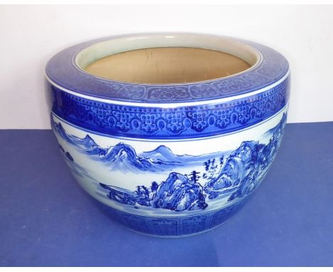 A large Chinese ceramic blue and white planter decorated with continuous landscape above lotus-style lappets (48cm diameter)