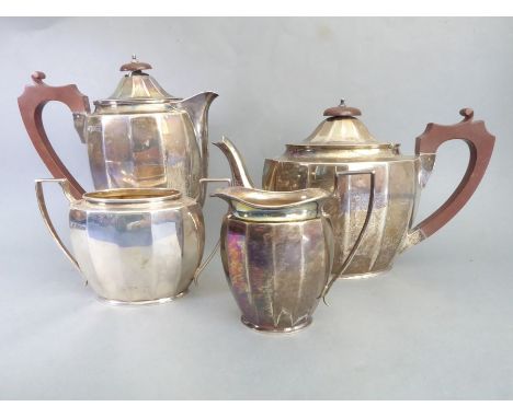 A hallmarked silver four-piece tea service comprising teapot, hot-water pot, two-handled sugar and milk jug, each of faceted 