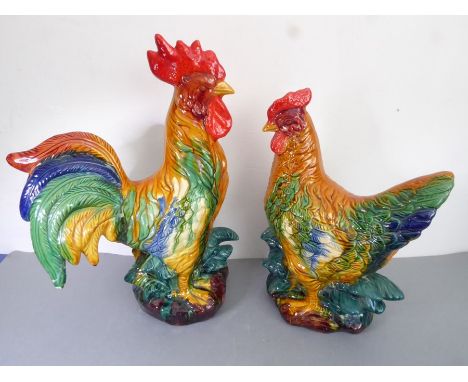 A ceramic cockerel decorated in majolica glazes, together with companion hen (20th century), a small piece away and a small r