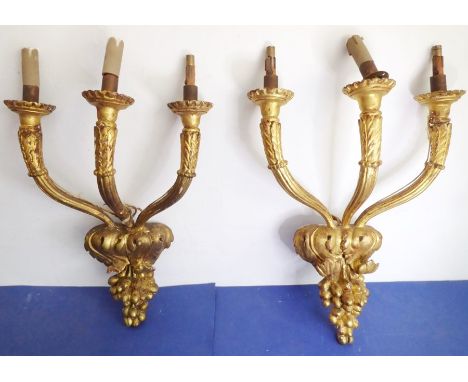 A pair of early 20th century carved gilt wood and gesso three-branch wall appliques for restoration; the branches emanating f