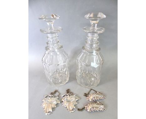 A pair of late Georgian ring-necked cut-glass decanters with original stoppers; together with two sets of two wine tickets