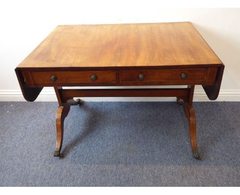 An early 19th century Regency period faded mahogany sofa table; two half-width drawers, two dummy drawers opposing, flanked b