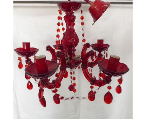 A cranberry-coloured five-light ceiling hanging glass candelabra