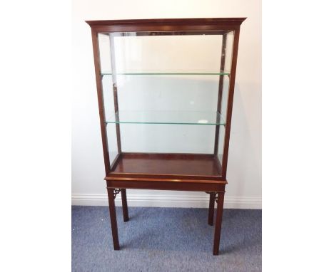 An early 20th century mahogany and glazed cabinet on stand in 18th century style; the glazed door enclosing glass shelves and