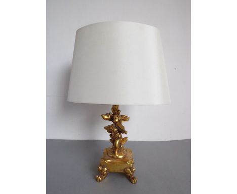 A giltwood table lamp modelled as a cherubic figure playing the violin (32.5cm including shade)