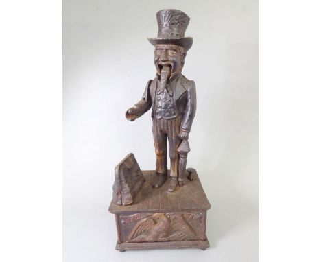 A cast-iron automaton 'Uncle Sam' novelty money box; the press-button action opens the bag and lowers the arm thus releasing 