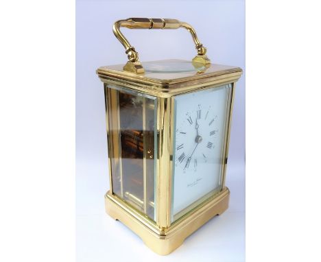 A good modern gilt-metal and glass-sided carriage clock timepiece; the white-enamel dial with Roman numerals and signed 'Baig