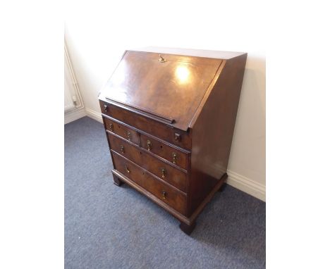 A good early 20th century walnut veneered writing bureau of small proportions; the cross- and feather-banded sloping fall ope