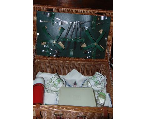 A vintage wicker picnic hamper with partially fitted interior containing a quantity of stainless steel cutlery, a tin flask, 