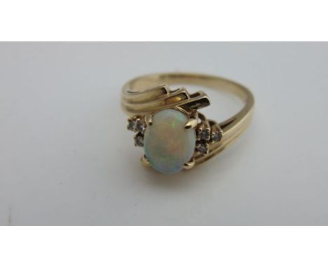 An opal and diamond ring, centred with an oval cabochon opal weighing approximately 1.0cts, flanked to each shoulder with thr