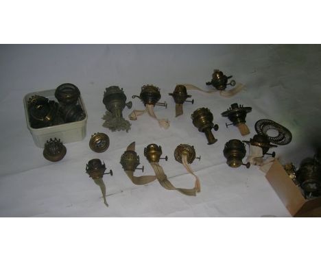 A box of various oil lamp burners and parts including Rowatts Patent Anucapnic burner, a Perfect, slip bulge duplex Kosmos, a