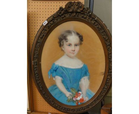 A mid-19th century pastel portrait of oval form showing a child in a blue dress holding a posy of flowers, signed bottom righ