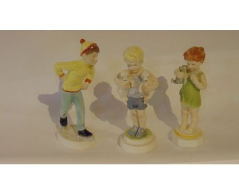 Three Royal Worcester figures - Mondays Child, in the form of a boy holding two puppies, Tuesdays Child, in the form of a boy