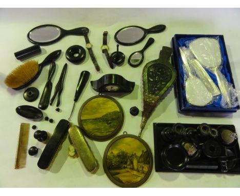 A quantity of ebony dressing tablewares including a small tray of rectangular form supporting a pair of candlesticks, pin cus