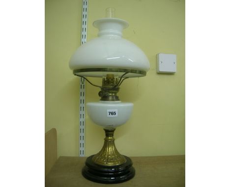 An early 20th century table lamp with domed/vesta opening glass shade and fount on a brass Art Nouveau stand with black ceram