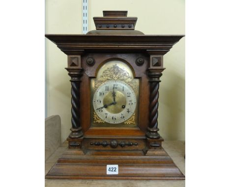 A late 19th century German bracket clock with walnut case, with spiral twist and other applied detail enclosing a broken arch
