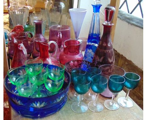 A selection of coloured glass to include two hand blown jugs, a carafe, a set of six wines with clear stems and feet, a furth