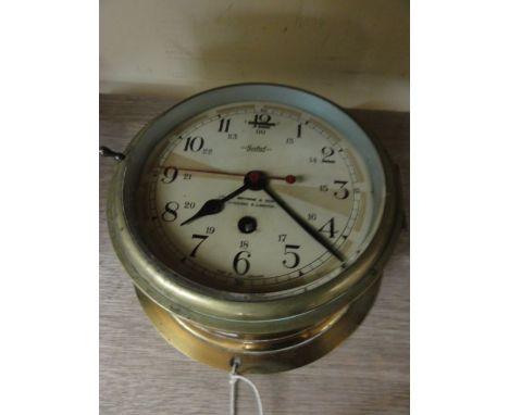 The Sestrel marine bulk head clock with centre sweep second hand set in a brass case