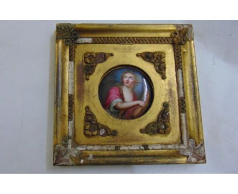 An 18th century miniature painting on enamel, of circular form, and showing a portrait of a young woman holding a lyre, her e