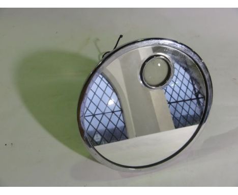 A vintage chromium framed wall mirror of circular form enclosing a frosted glass aperture with bevelled border set before a p