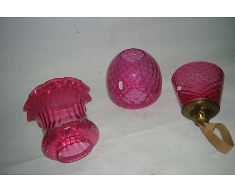 Three cranberry shades, one originally a glass lamp shade mounted on a duplex screw in burner, a beehive duplex shade and a c