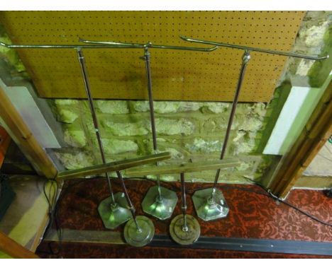 A trio of vintage chromium adjustable T shaped display stands raised on weighted iron bases with canted corners, 94 cm tall a