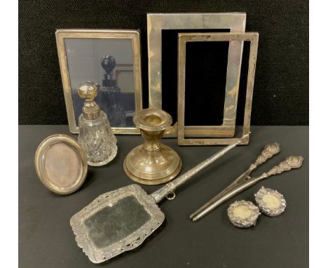 A George V silver photograph frame, Birmingham 1912; other silver frames; a Continental silver coloured metal hand mirror; a 