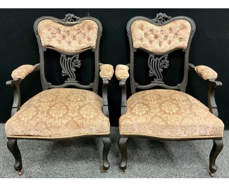 A pair of Victorian ‘Rococo’ style carved armchairs, upholstered button-backs, upholstered arms, and sprung seats, ceramic ca