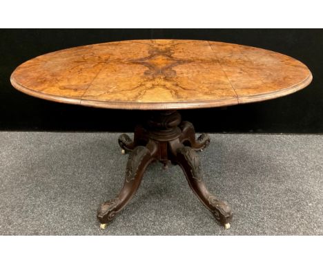 A Victorian Burr Walnut and walnut drop-leaf pedestal centre table, the oval top with moulded edge, raised on a turned balust