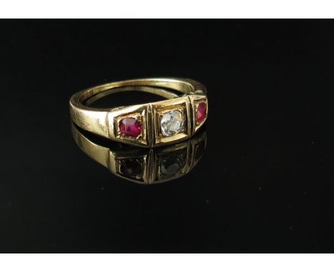 A gold ruby and diamond ring the central brilliant cut diamond flanked by rubies, unmarked, size L, worn, 3g