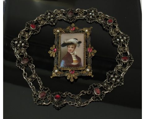 A 19th Century garnet choker and porcelain portrait brooch in elaborate frame