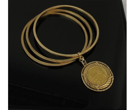 An 18ct gold triple bangle hung with an 1962 gold sovereign in ornate mount, 13.5g