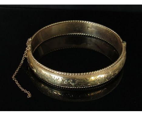 A 9ct gold engraved bangle, 19.4g